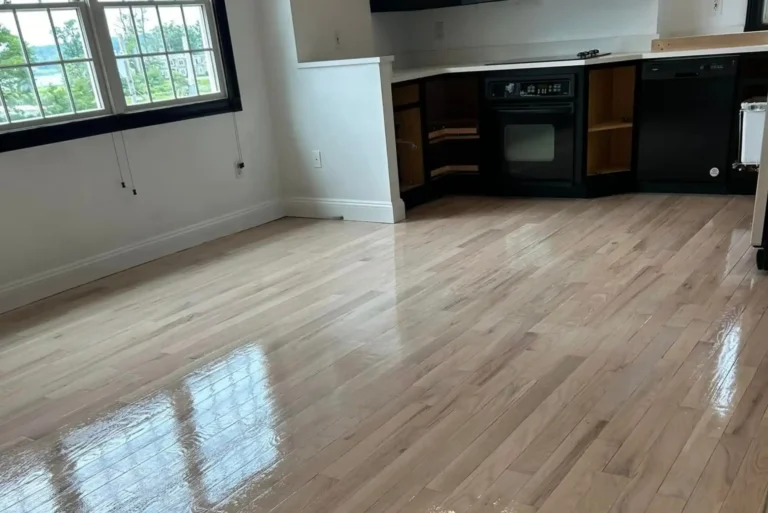 Newly refinished hardwood floor with a glossy finish in a modern kitchen - expert wood floor restoration.