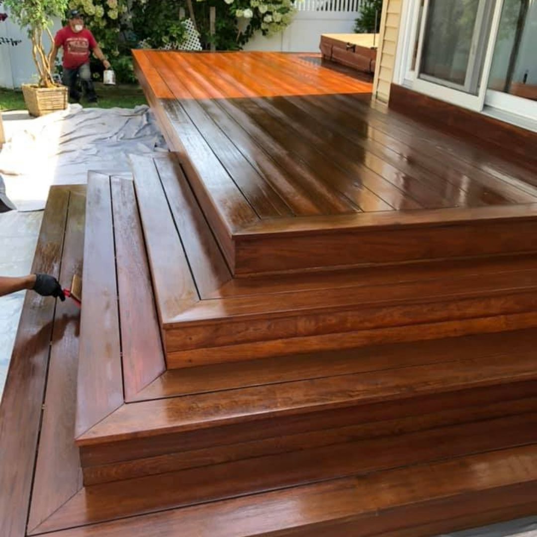 Outdoor-wooden-deck-refinishing-with-a-fresh-glossy-finish-and-detailed-craftsmanship-on-the-steps.jpg